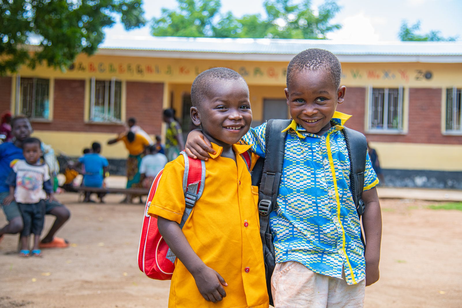 Two boys standing outside the early childhood development center posing for a picture.