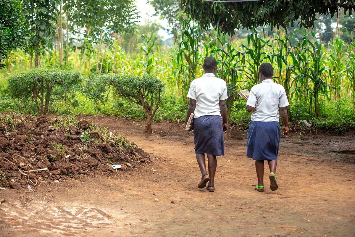 Two girls are pictured here walking together in their school uniforms.