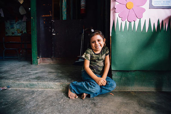 Young girl sitting outside smiling
