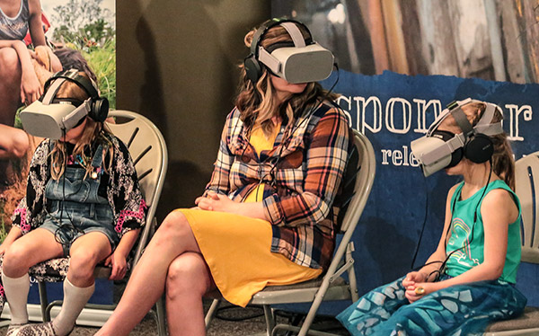 A mother and two girls using VR goggles