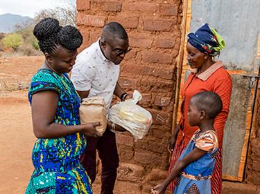 A couple deliver food to a child in Compassion's program.