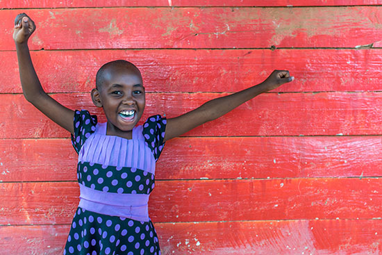 A young girl celebrating by raising her arms