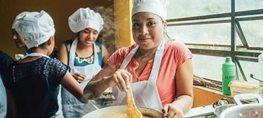 a girl stirs a pot of soup