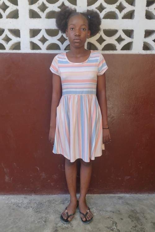 An unsponsored girl named Reginie from Haiti who is vulnerable to exploitation and has waited 620 days for a sponsor.
