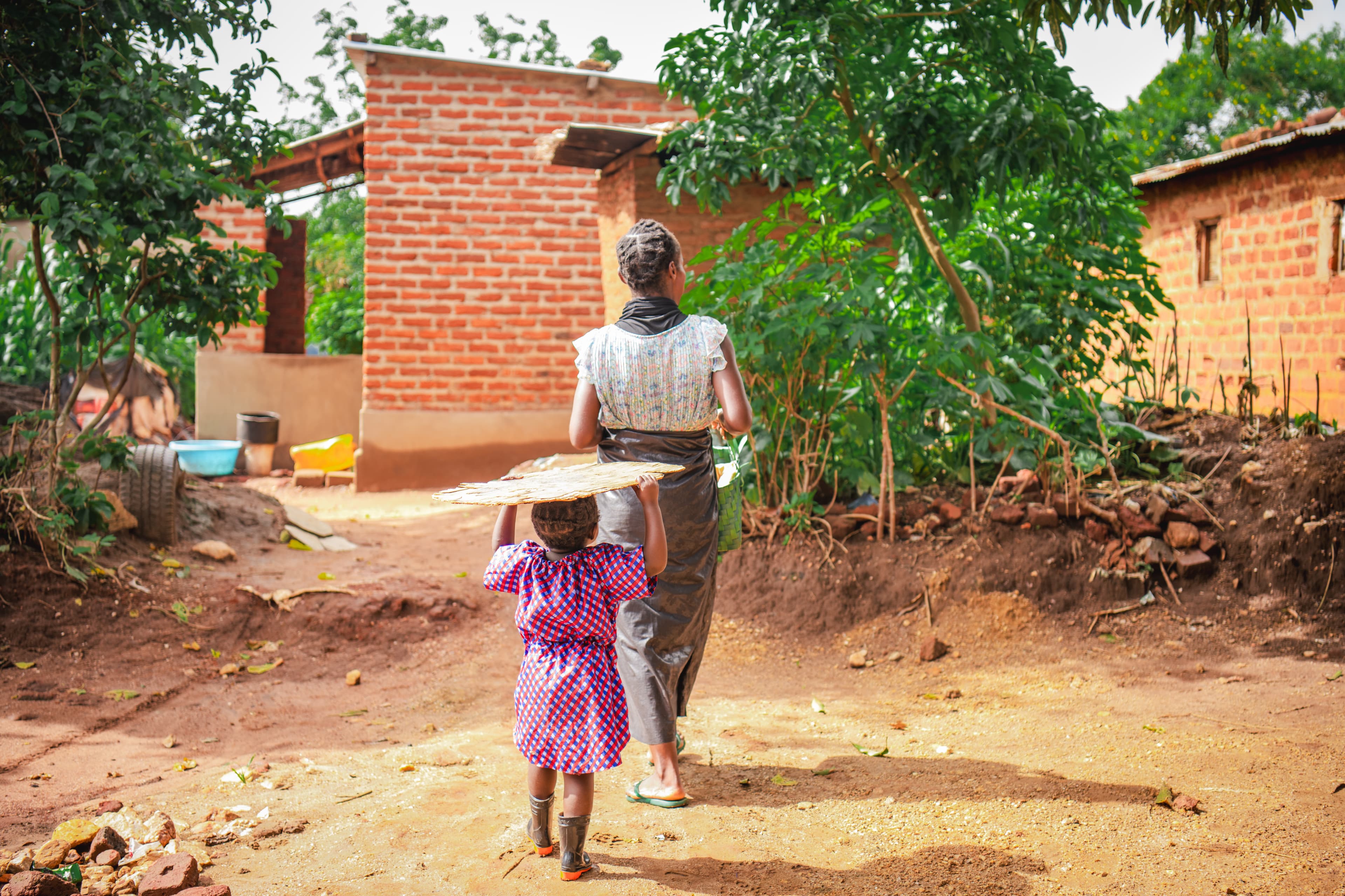 A mother and daughter are walking through their village together.