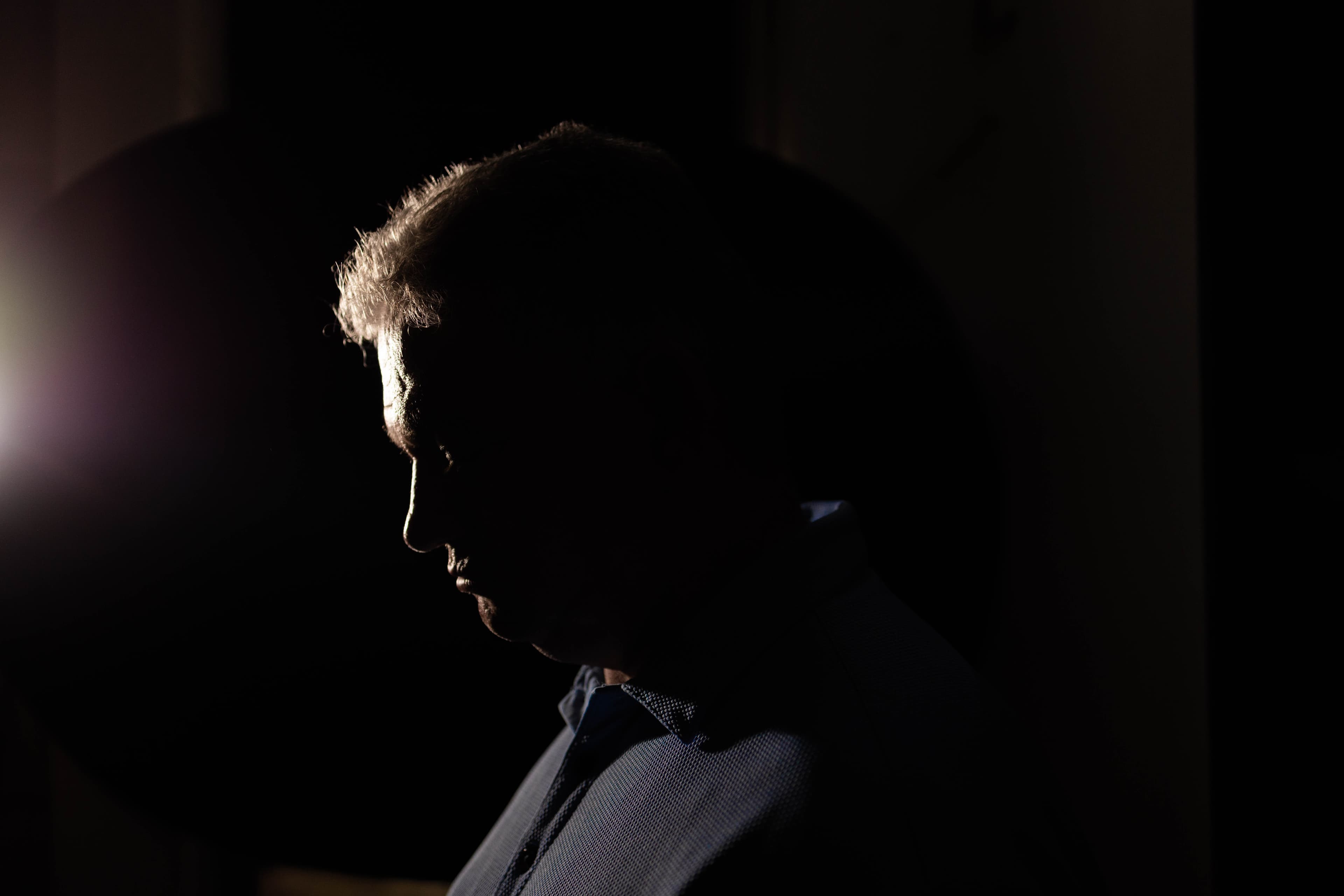 A silhouette of a man with a light shining behind him.