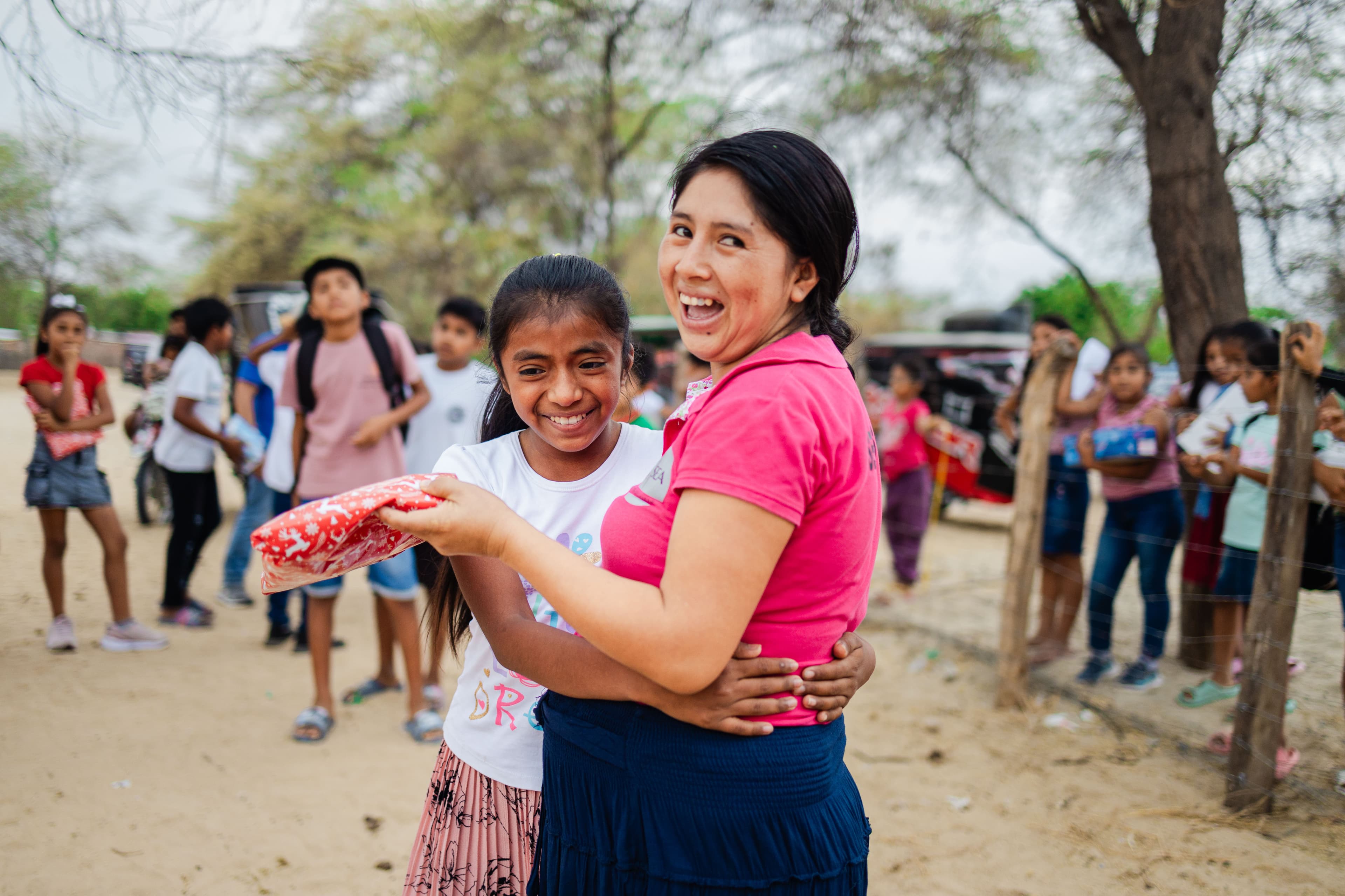 A young girl is receiving a gift from her tutor.