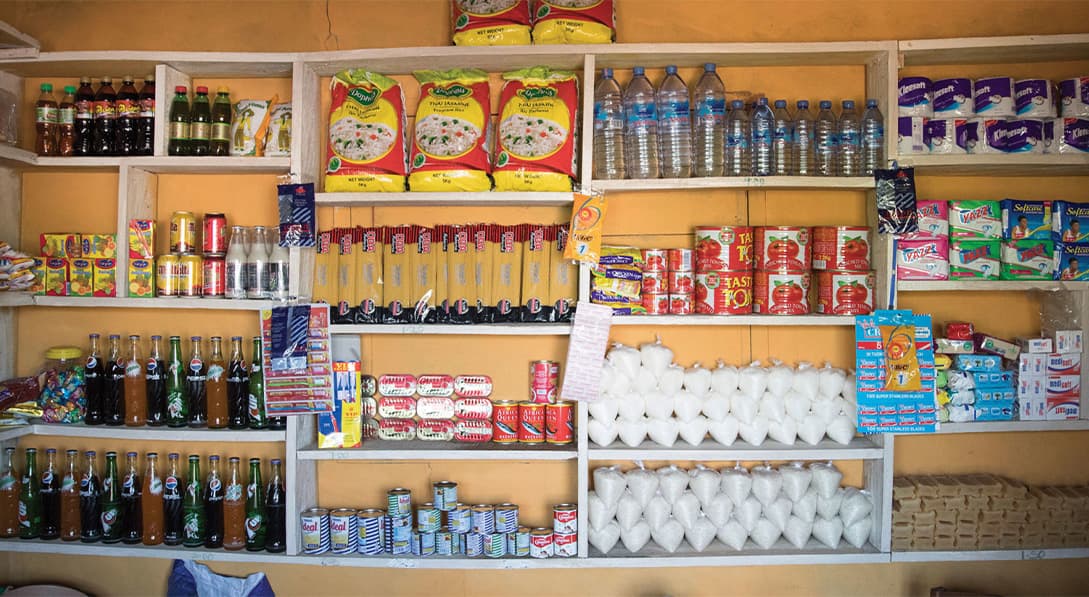 A photo of grocery store shelves in front of a yellow wall.