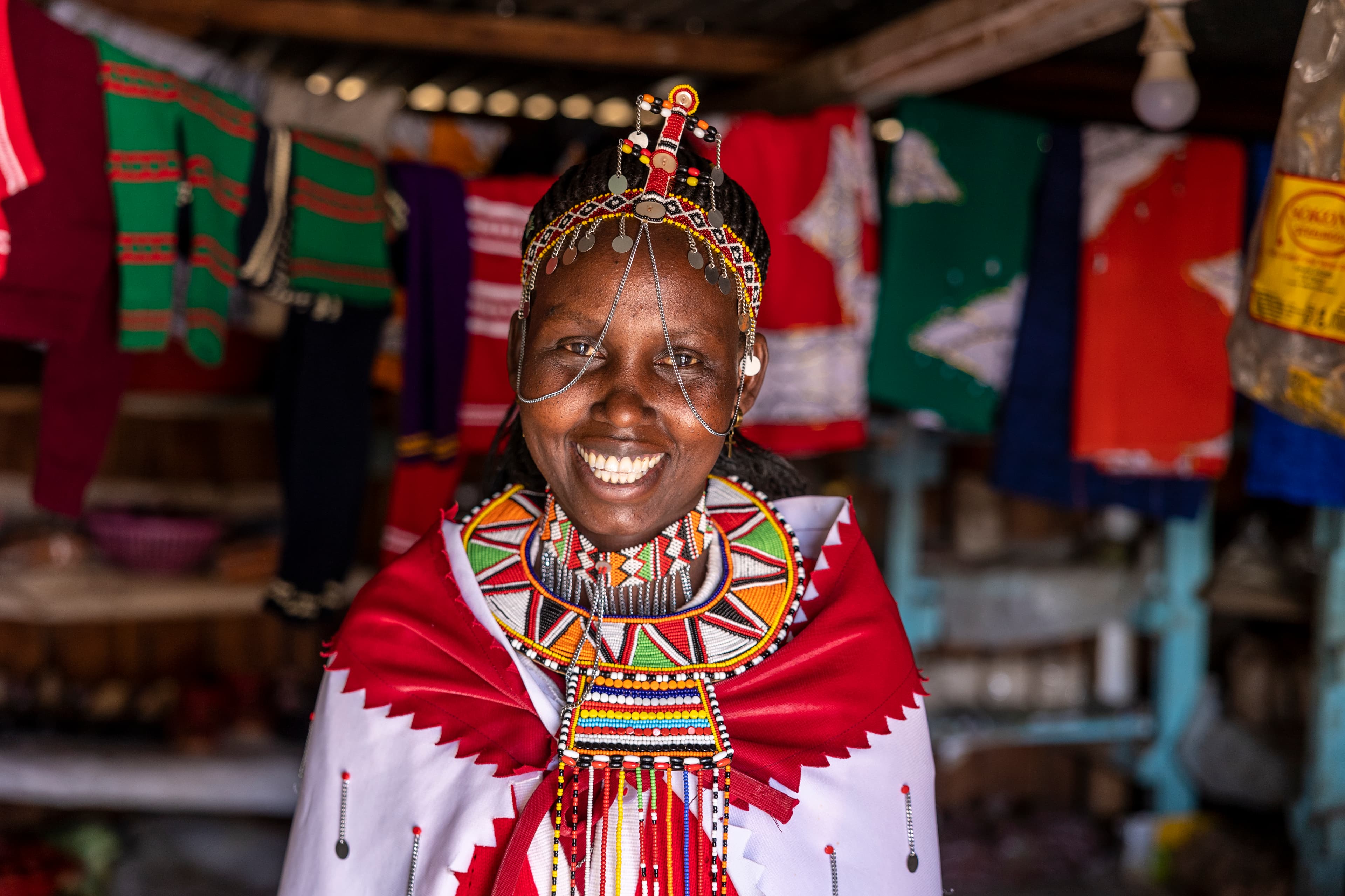 A woman is smiling as she stands inside the shop she runs together with her husband.