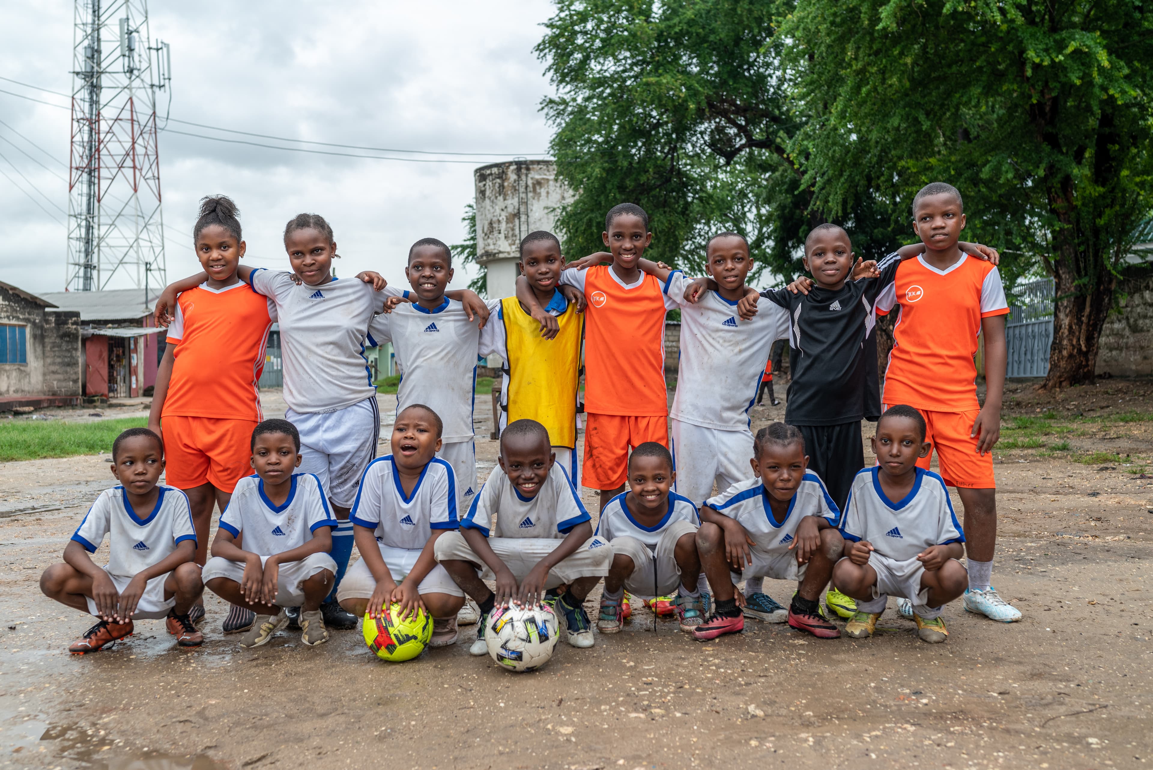 A group of boys wear soccer uniforms and pose while smiling.