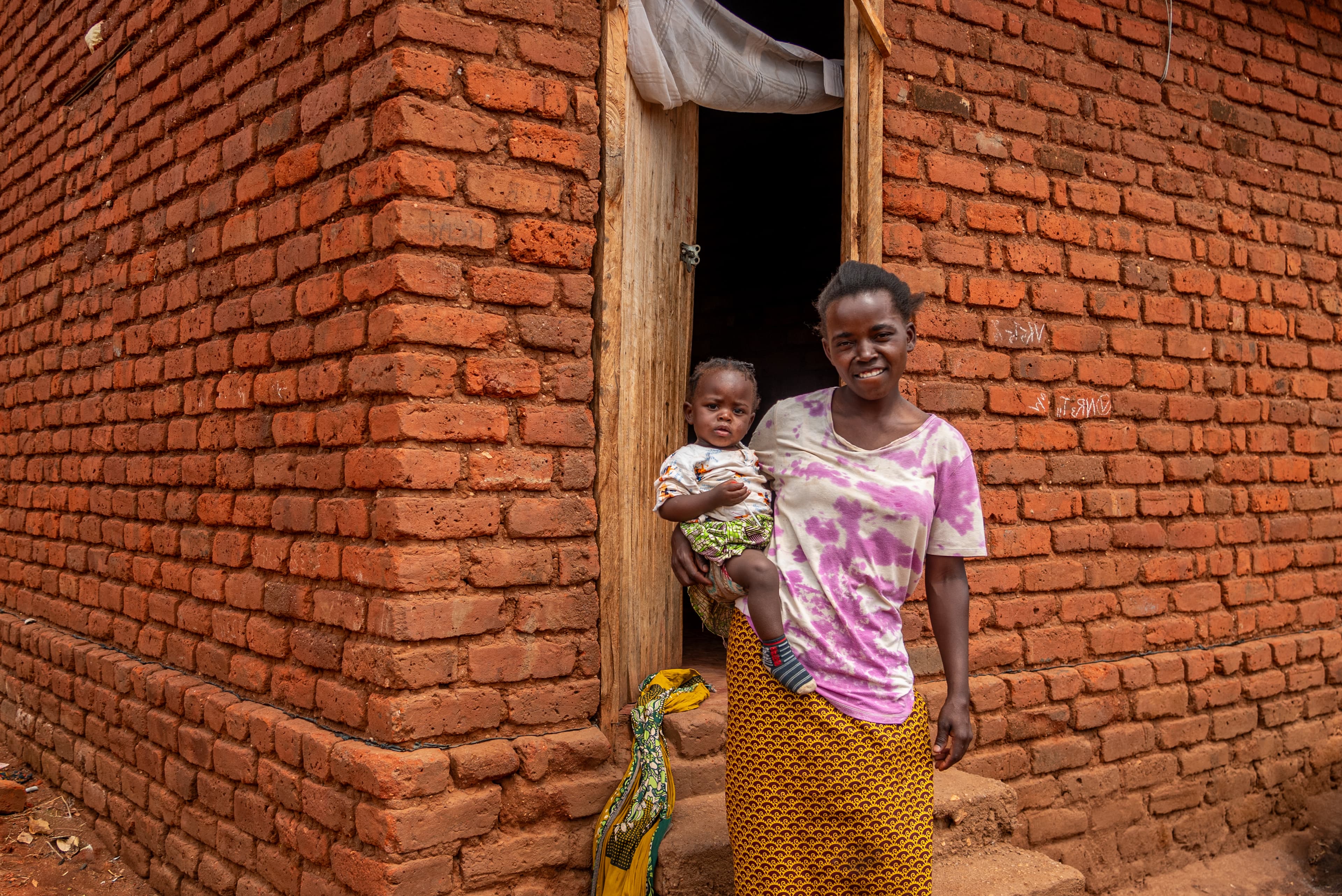 A mother is standing with her baby sitting on her hip.
