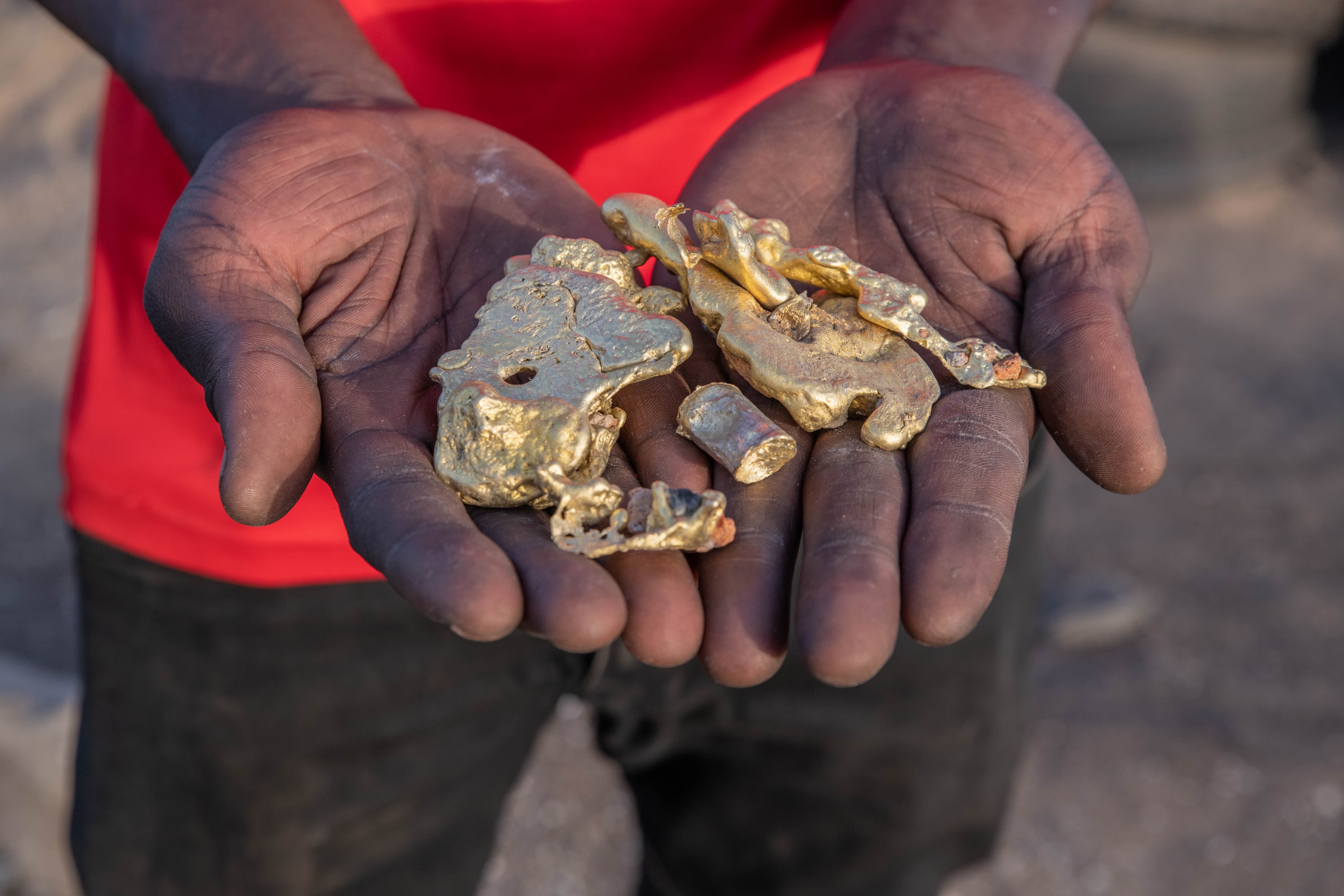 An African boy’s hands holding pieces of cast bronze.