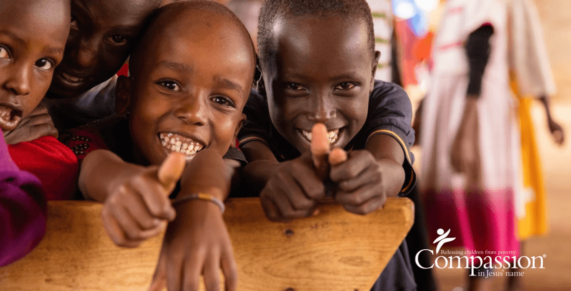 Children smile and put thumbs up