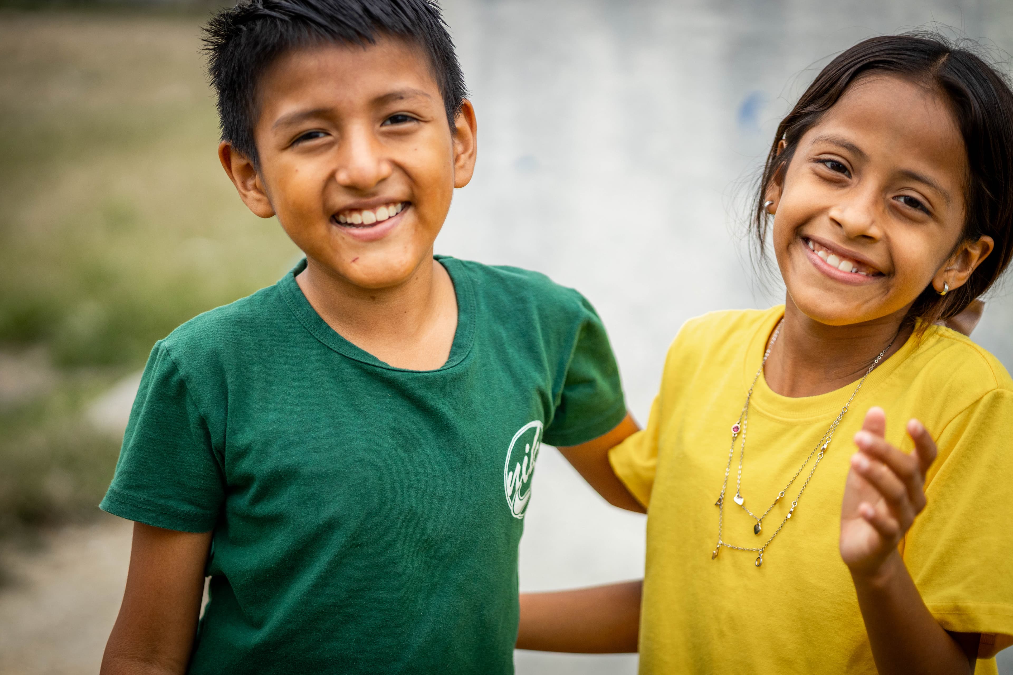 Portrait of a young boy and girl standing together and laughing.