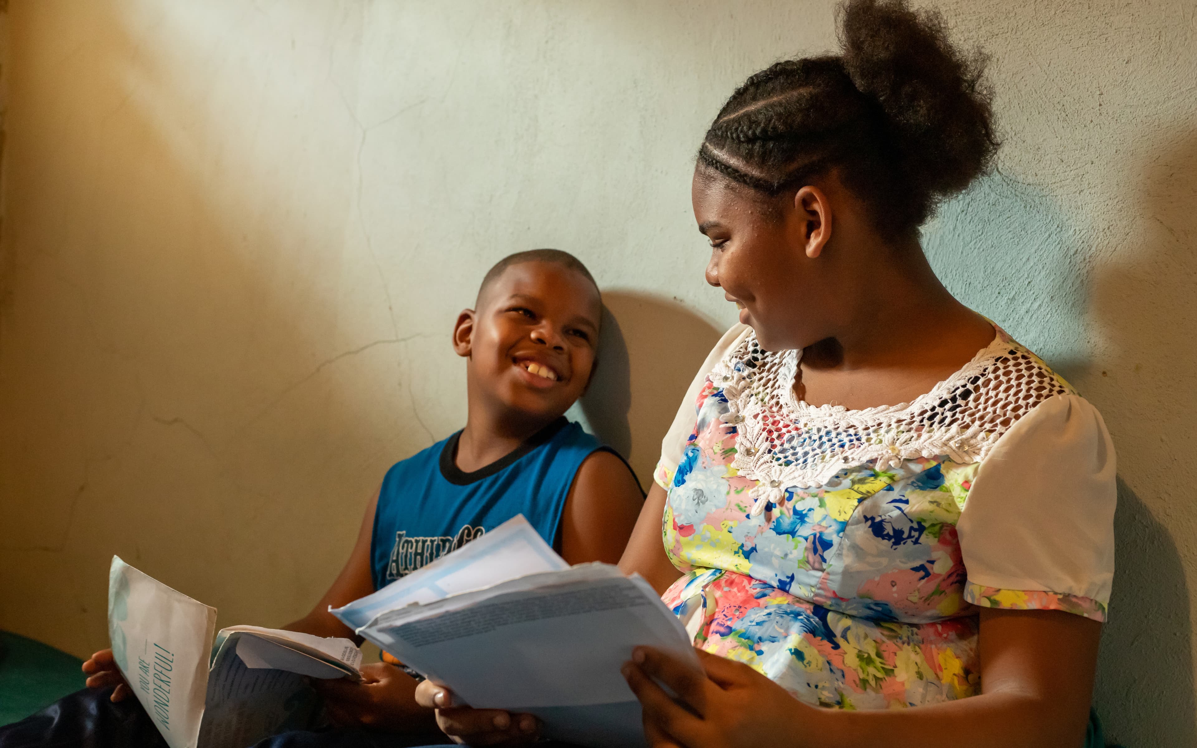 a young boy is sitting with his mother smiling.