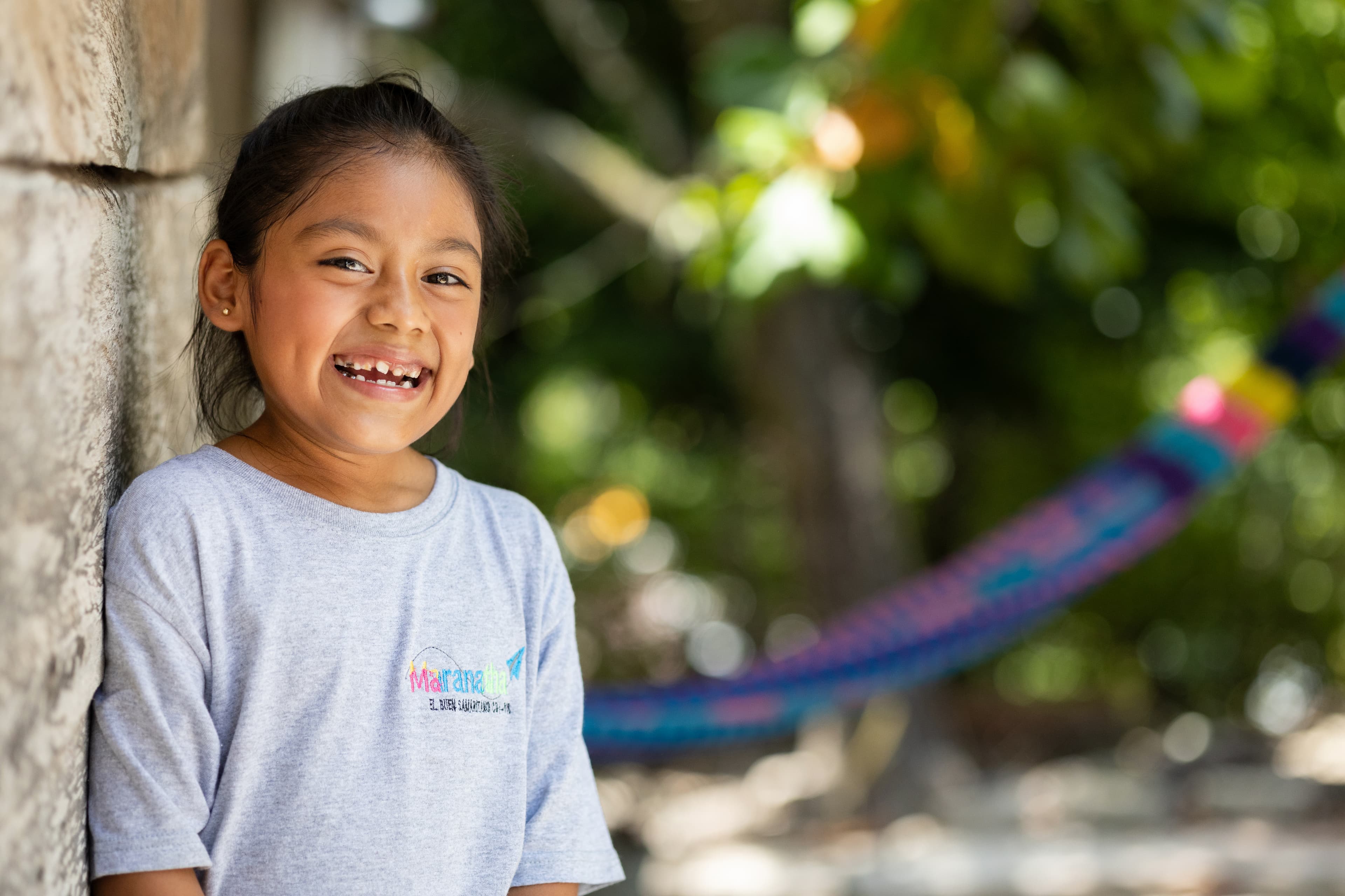 A young girl smiles widely for the camera.