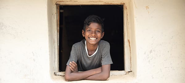 Boy leaning out of a window smiling