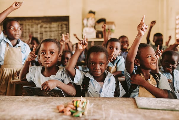 Children is Togo classroom raising hands