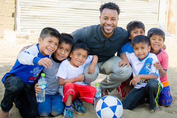 A pastor smiles with a group of children