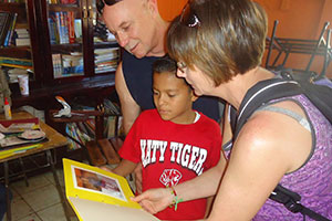 A man and woman show a folder to a young boy