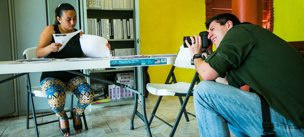 A Compassion photographer capturing a picture of a woman working in the child development center