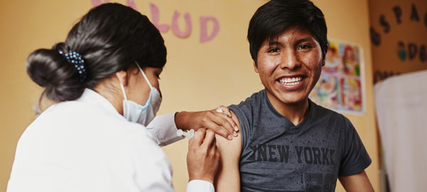 A boy receiving his vaccine shot from a medical professional