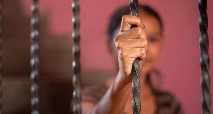 Hope sitting behind a stair rail with her hand in front of her face