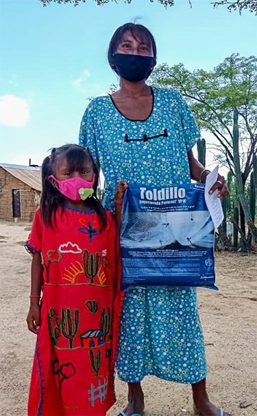 a girl and her mother hold a mosquito net