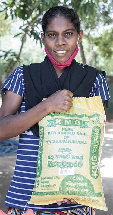 a woman holds a bag of rice