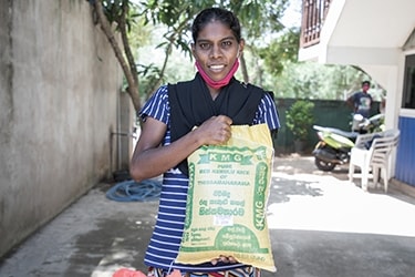 a woman holds a bag of rice